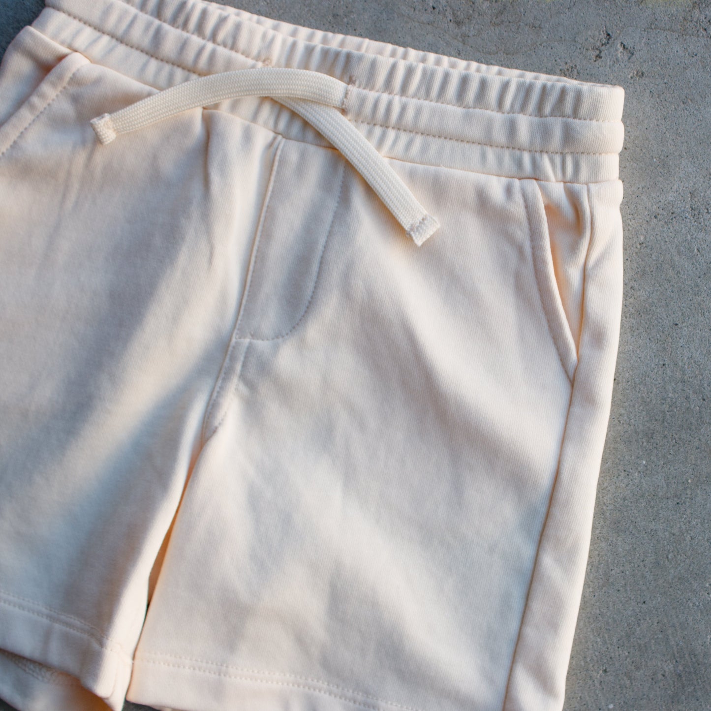 Beige shorts on a gray concrete surface