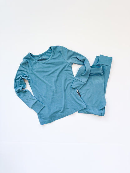 Blue long-sleeve shirt and pants set on a white background