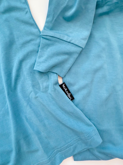 Close-up of a blue garment with a brand tag on a white background
